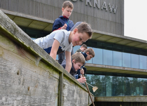 Kinderen zoeken waterdiertjes bij het NIOO