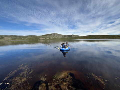 Researchers in a boat sample a lake near Kangerlussuaq, Greenland, that browned after the extreme events.