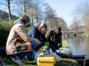 Burgerwetenschapper doet samen met de onderzoeker metingen rondom een riooloverstort